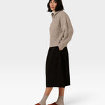 Model wearing a JONES + CO oversized marble shawl-neck sweater in alpaca and Pima cotton blend with a black skirt.