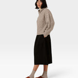 Model wearing a JONES + CO oversized marble shawl-neck sweater in alpaca and Pima cotton blend with a black skirt.