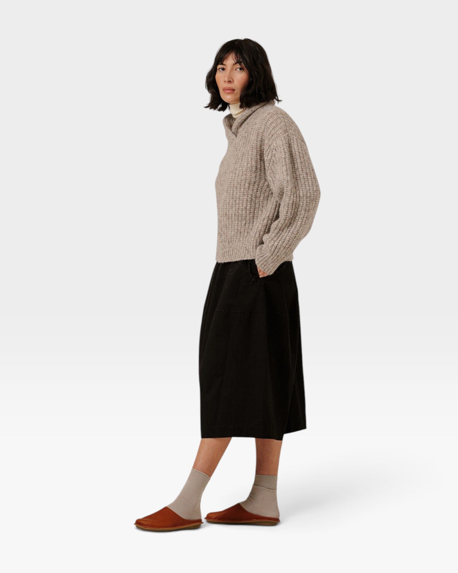 Model wearing a JONES + CO oversized marble shawl-neck sweater in alpaca and Pima cotton blend with a black skirt.