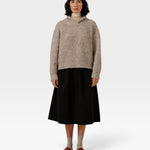 JONES + CO oversized marble shawl-neck sweater in alpaca and Pima cotton blend worn with a black midi skirt