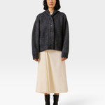 JONES + CO oversized dark navy shawl cardigan in alpaca and Pima cotton blend worn by a model with a cream skirt.