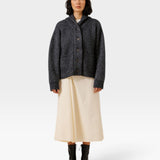 JONES + CO oversized dark navy shawl cardigan in alpaca and Pima cotton blend worn by a model with a cream skirt.