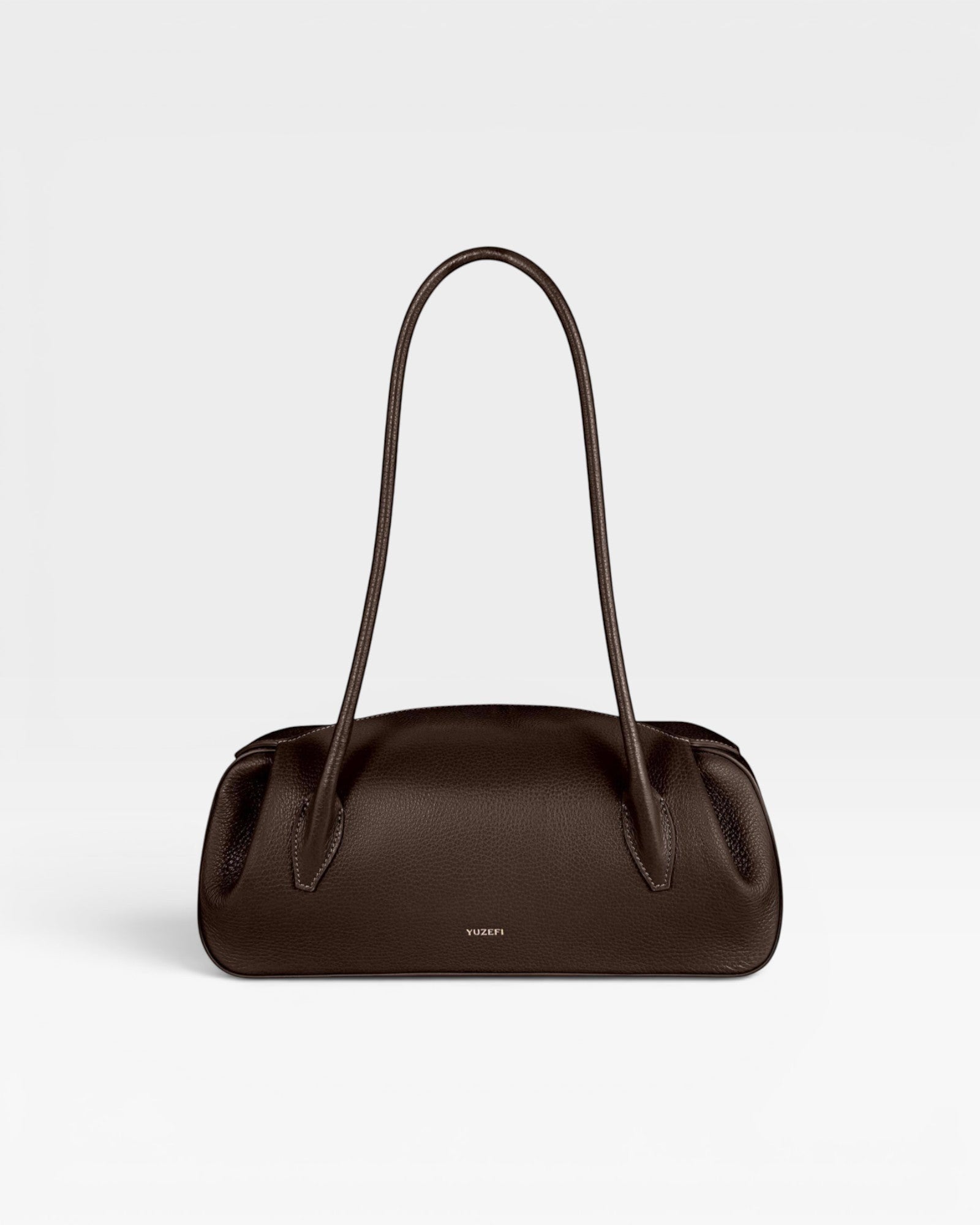 JONES + CO Oyster shoulder bag in espresso brown pebbled leather with a structured, elongated silhouette.