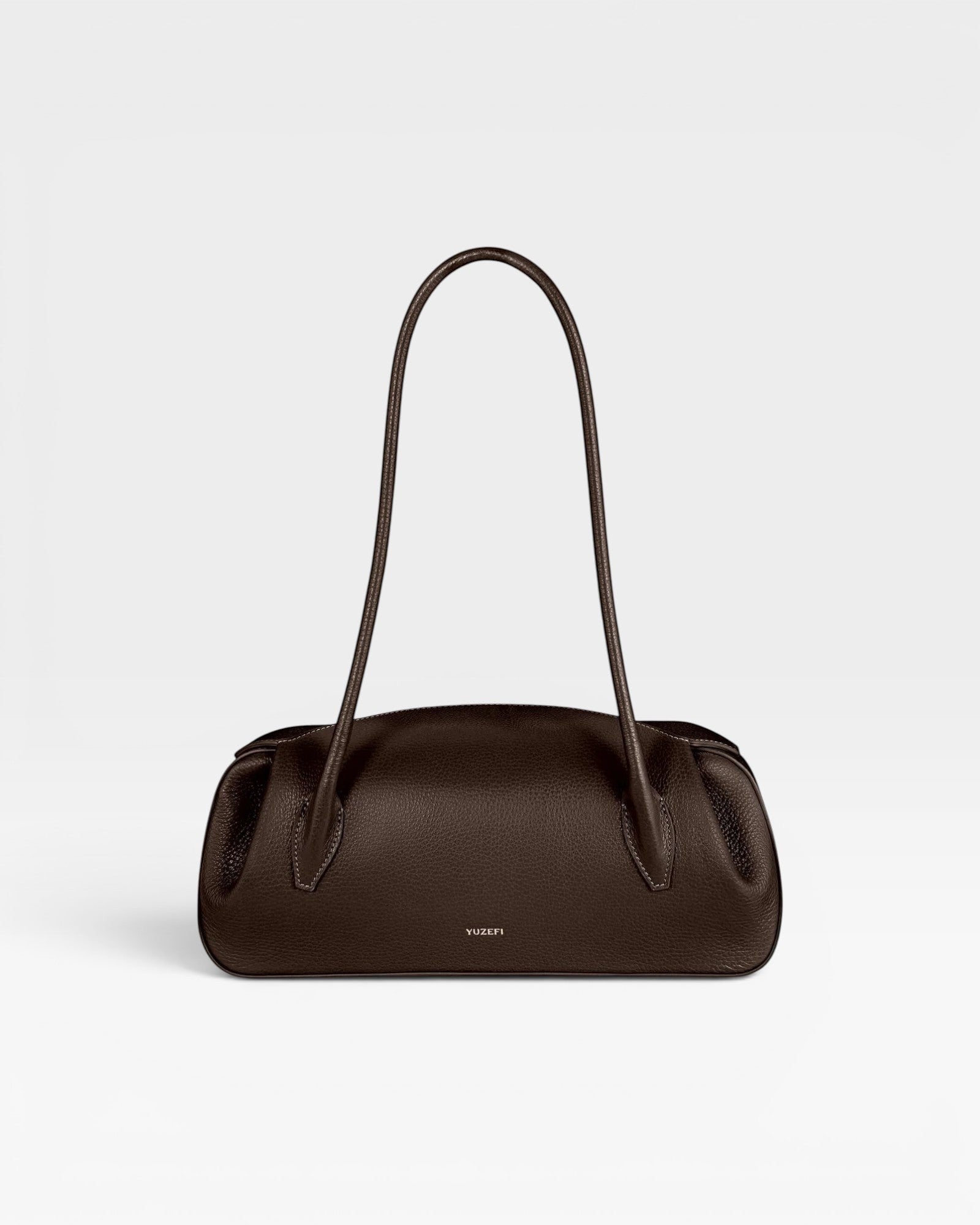JONES + CO Oyster shoulder bag in espresso brown pebbled leather with a structured, elongated silhouette.