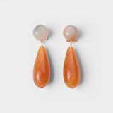 JONES + CO Pamploma sculptural acrylic earrings with cream spherical studs and orange tear-shaped drops.