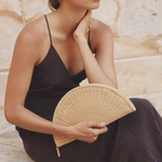 JONES + CO Perla Clutch in caramel basketweave leather, shaped like a seashell with a wrap-around zip.