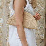 JONES + CO Perla Clutch in caramel, a woven basketweave leather seashell-shaped bag with wrap-around zip.
