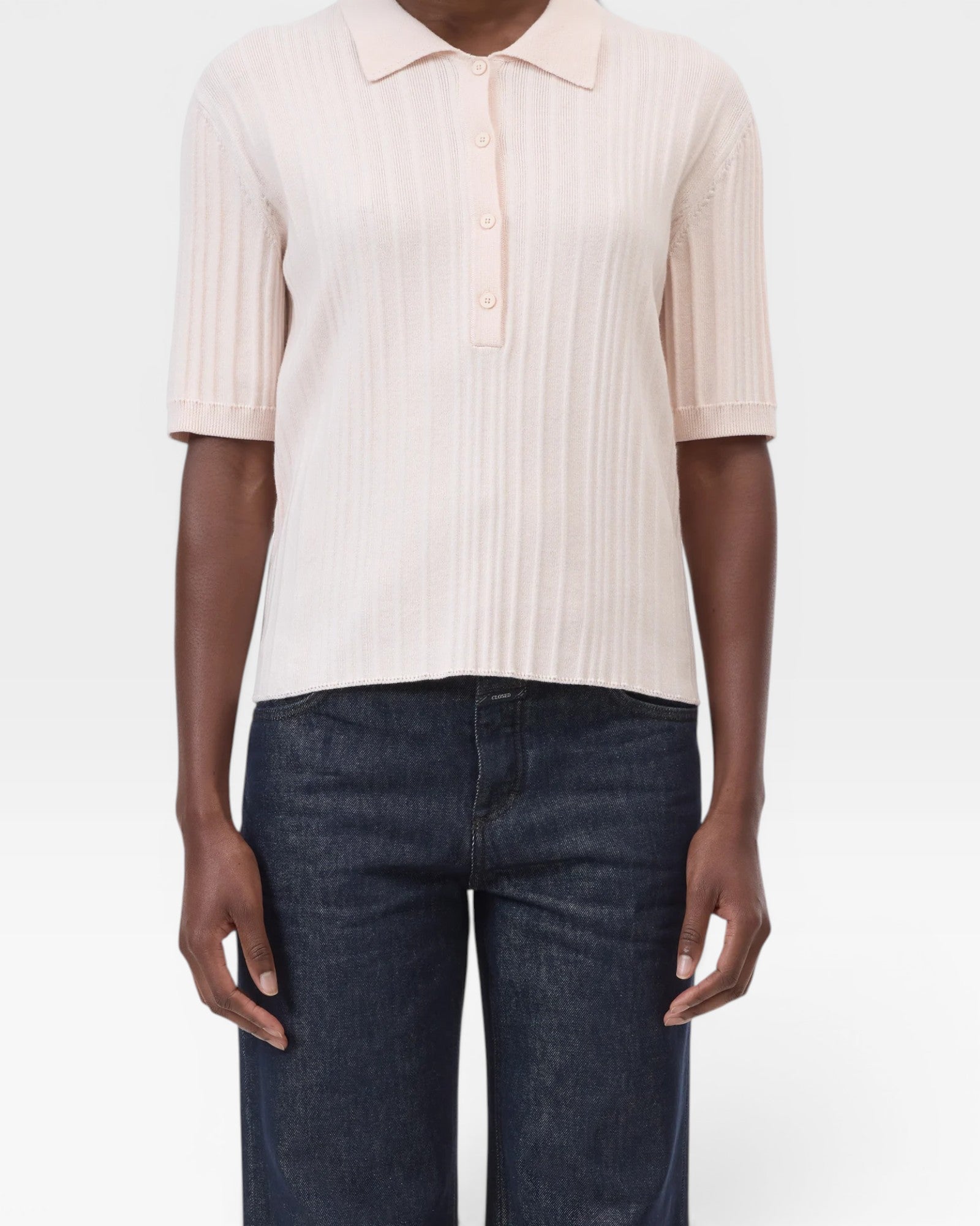 JONES + CO pale pink ribbed short sleeve polo shirt with a smooth collar and cuffs, made from cotton, cashmere, and wool.