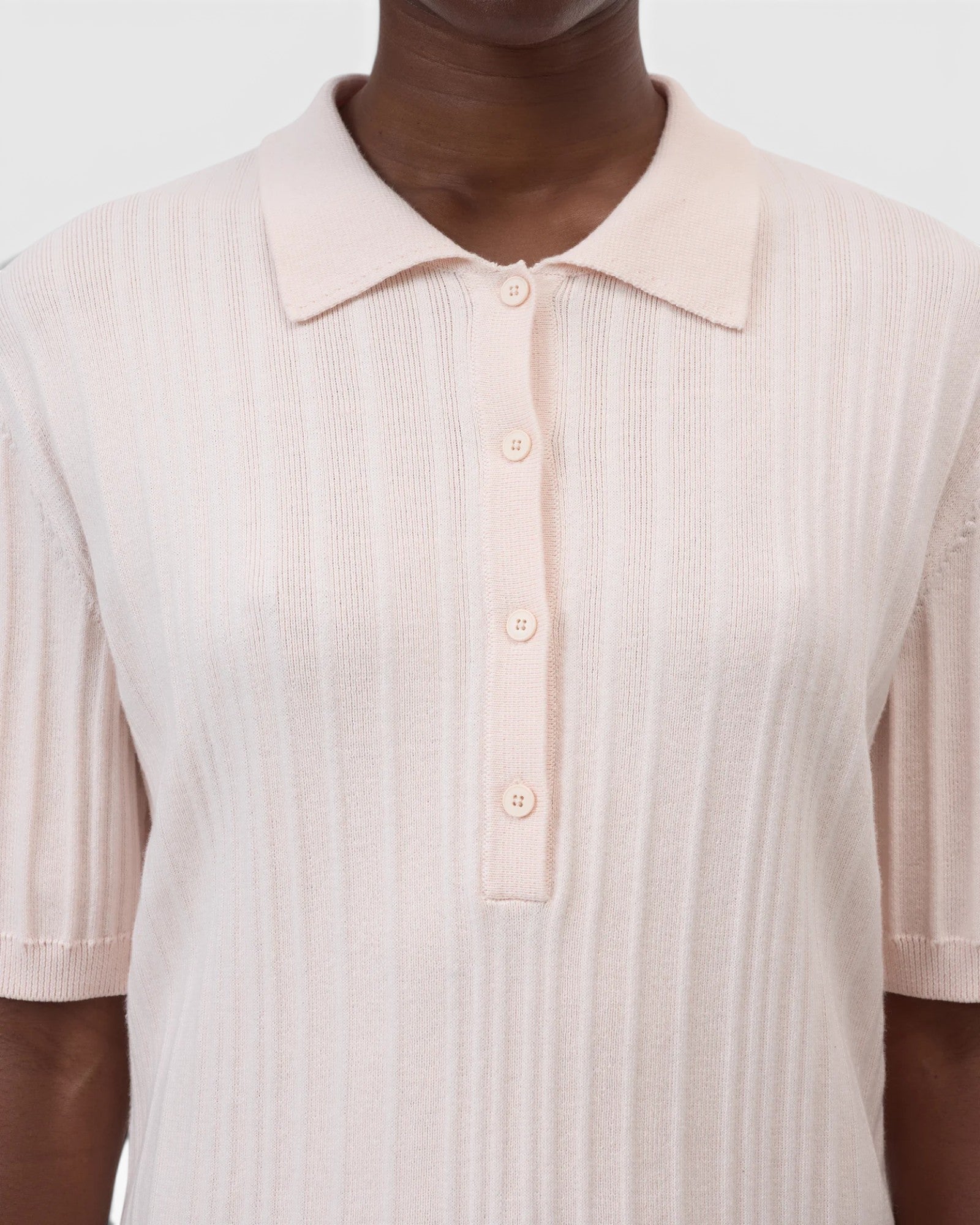 JONES + CO light pink ribbed short sleeve polo shirt with a smooth collar and cuffs.