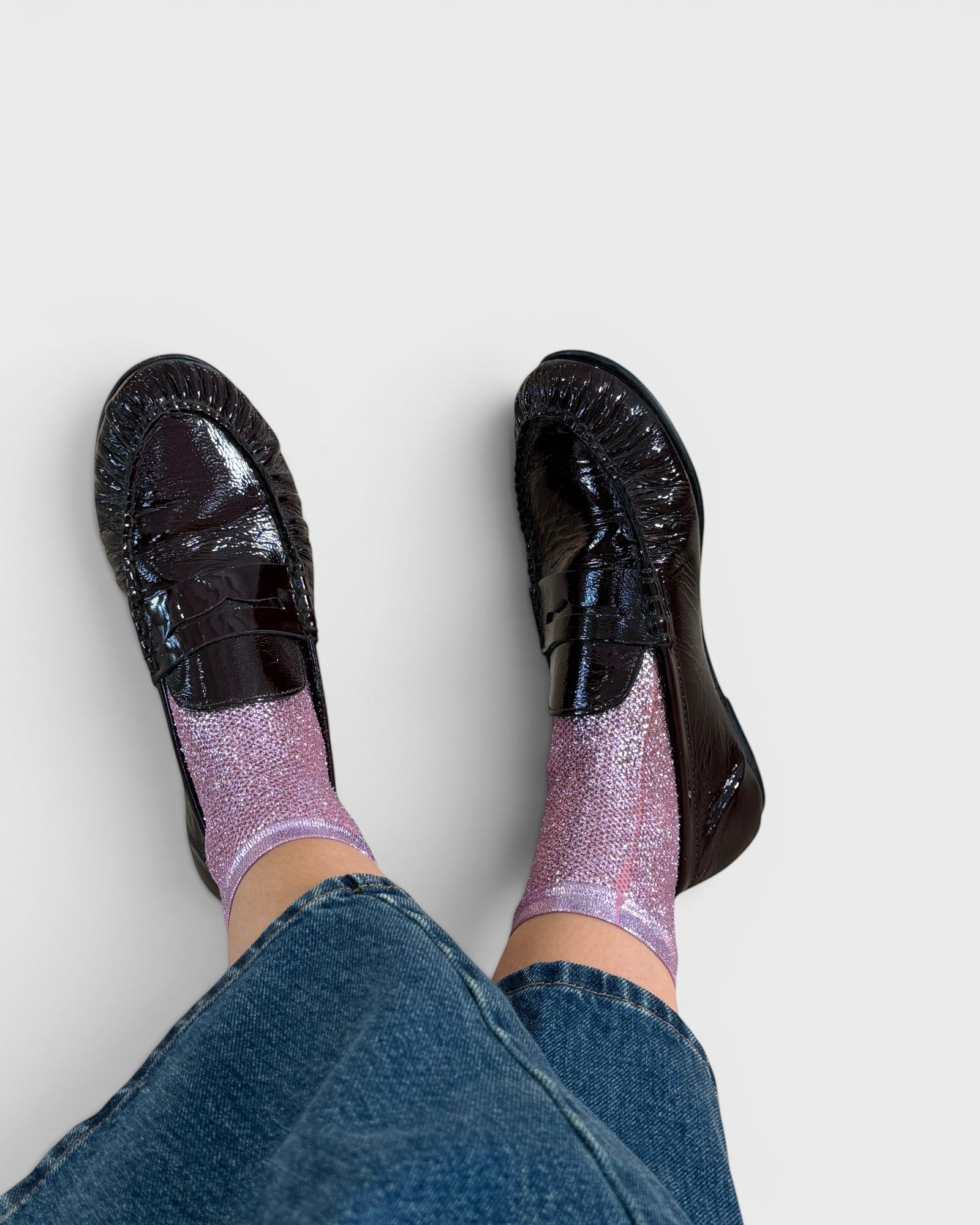 JONES + CO shimmering pink ribbed silk socks worn with dark brown patent leather loafers and blue denim jeans
