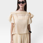 JONES + CO cream pleated linen blend top with flutter sleeves and wide leg pants with drawstring waist.