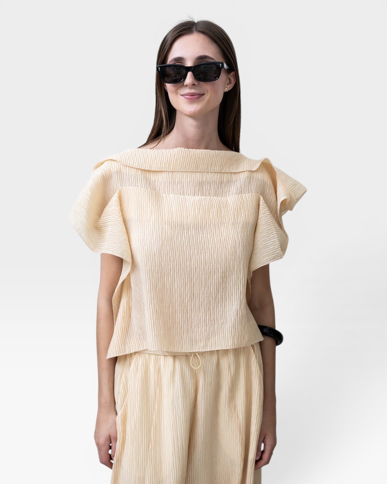 JONES + CO cream pleated linen blend top with flutter sleeves and wide leg pants with drawstring waist.