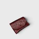 JONES + CO plum cowhide cardholder with a solid brass fastener, featuring a textured hair-on-hide finish.