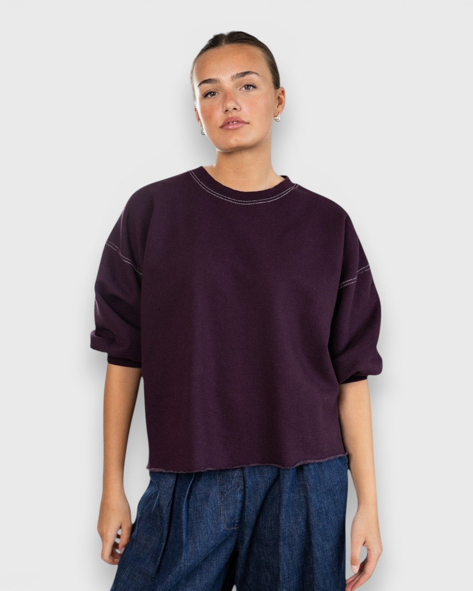 JONES + CO Rachel Comey plum crewneck sweatshirt with drop shoulders, cropped sleeves, and raw edge hemline.
