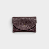 JONES + CO plum leather cardholder with a solid brass fastener and textured finish on a light grey background