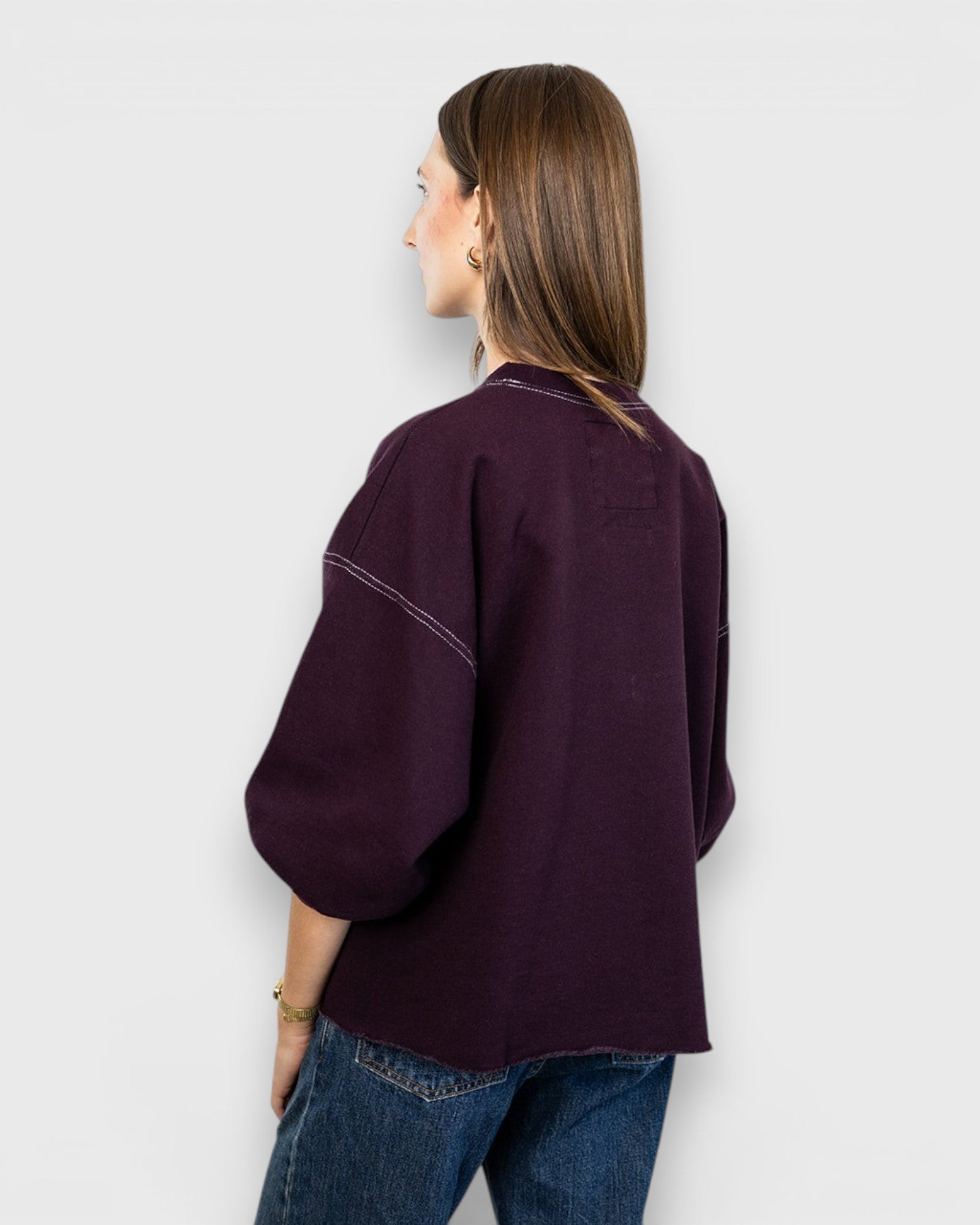JONES + CO Rachel Comey Fond sweatshirt in plum with drop shoulders and raw edge hem, back view on a model.