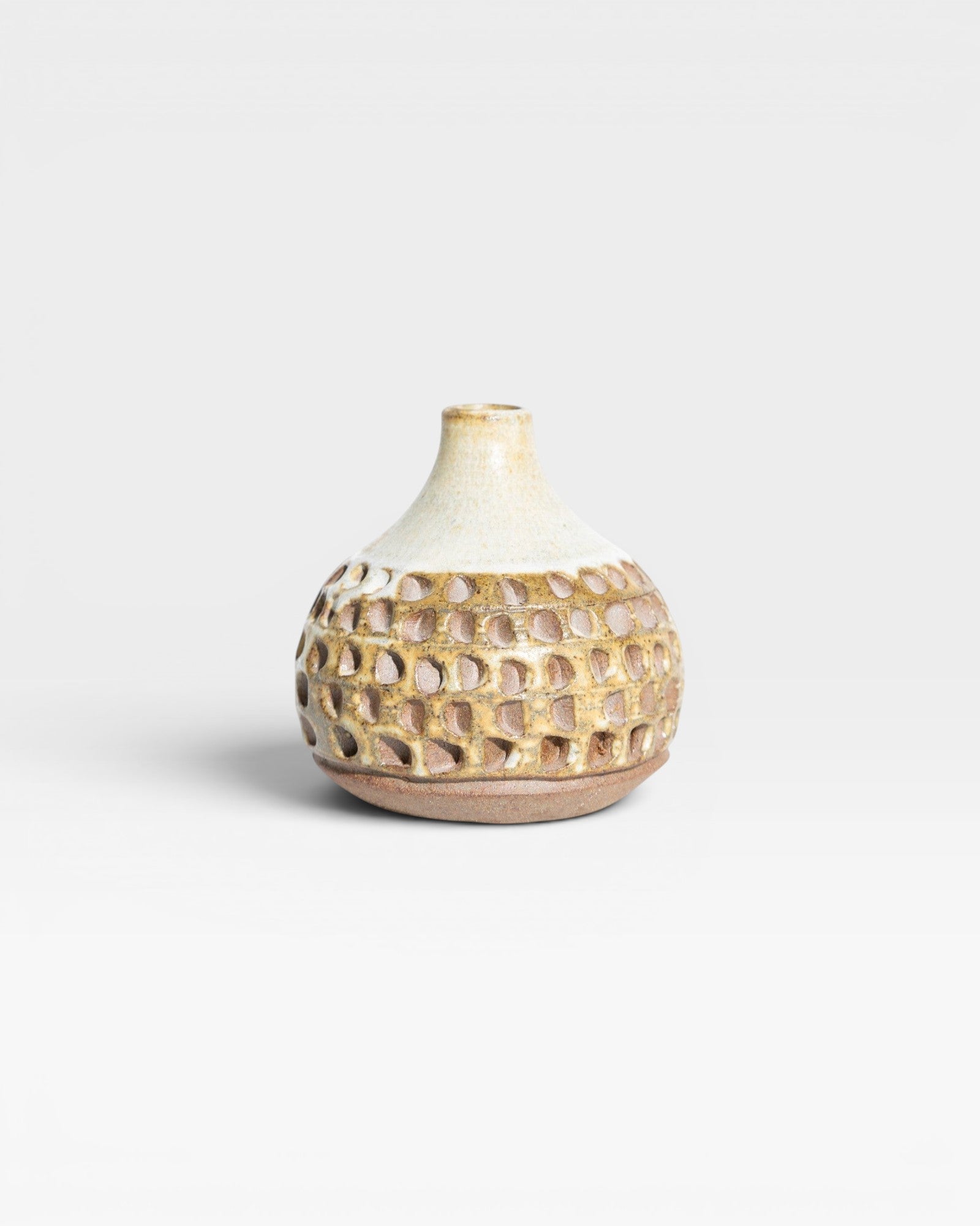 JONES + CO Stone Fired Prambanan Vase with a textured, carved pattern in earthy tones and a cream glaze.