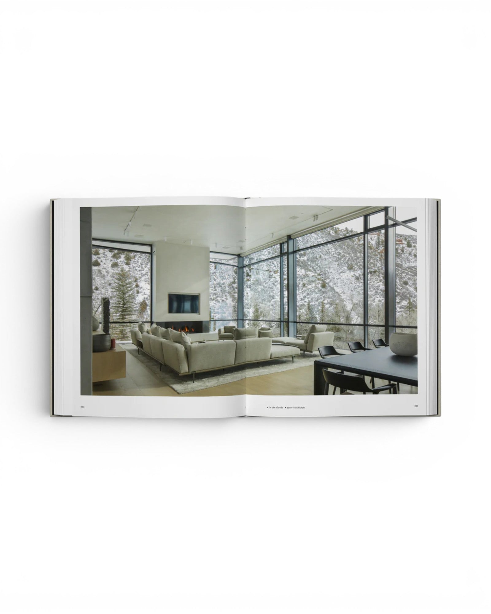 JONES + CO Private Aspen book open to a page showing a modern living room with floor-to-ceiling windows and mountain views