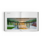 JONES + CO Private Aspen book open to a spread showing a modern mountain home with glass walls and a white sofa.