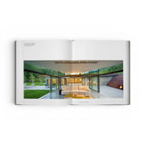JONES + CO Private Aspen book open to a spread showing a modern mountain home with glass walls and a white sofa.
