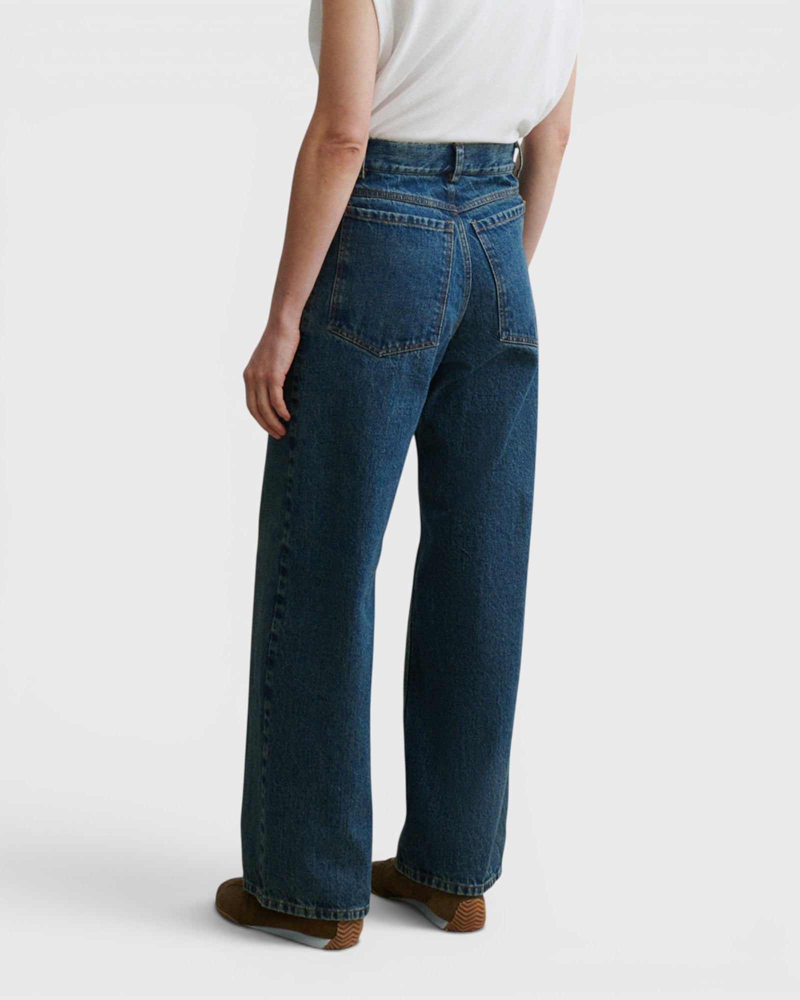 JONES + CO Puerto high-rise straight leg jeans in aged indigo cotton denim, back view on a model.
