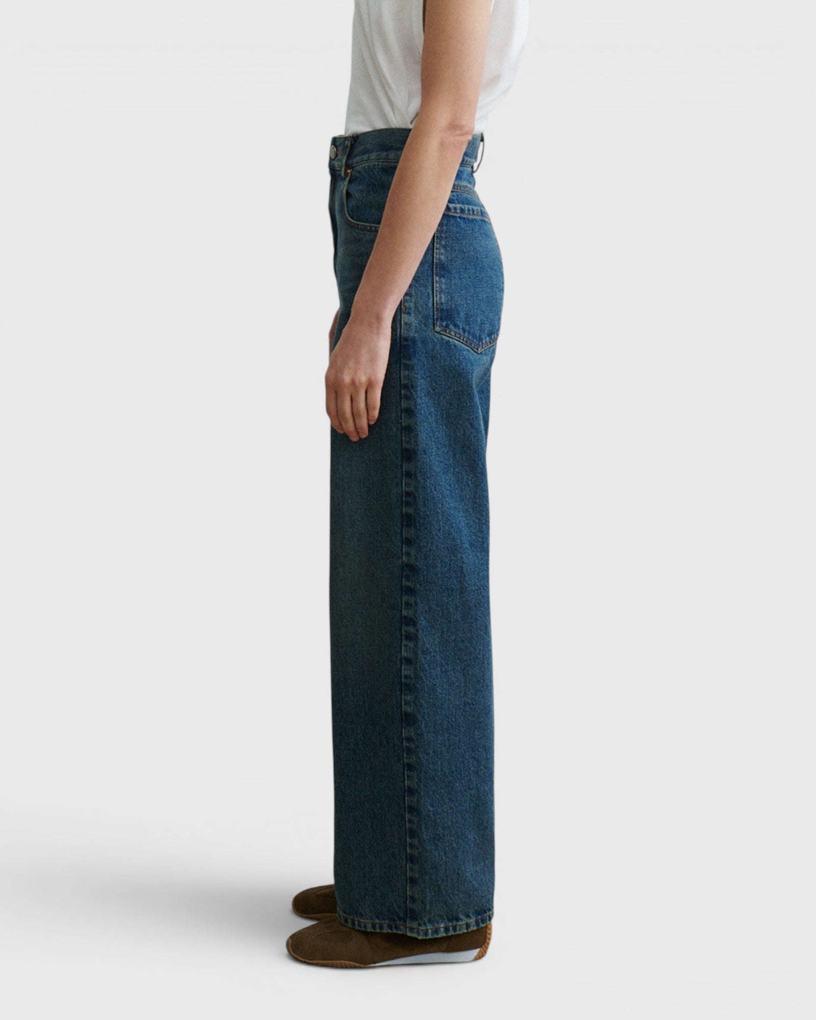 JONES + CO Puerto high-rise straight leg jeans in aged indigo cotton denim, side profile view on a model.