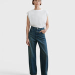 JONES + CO Puerto Pant in aged indigo cotton denim, a high-rise straight-leg jean worn by a model.