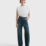 JONES + CO Puerto Pant in aged indigo cotton denim, a high-rise straight-leg jean worn by a model.