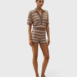 Model wearing JONES + CO Raya polo top in Lais stripe crochet knit with collared neckline and short sleeves.