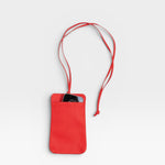 JONES + CO red pebble leather Paris Phone Purse crossbody bag with a phone inside.