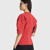 JONES + CO red crew-neck top with short puff sleeves and metallic thread detail worn by a model in profile view