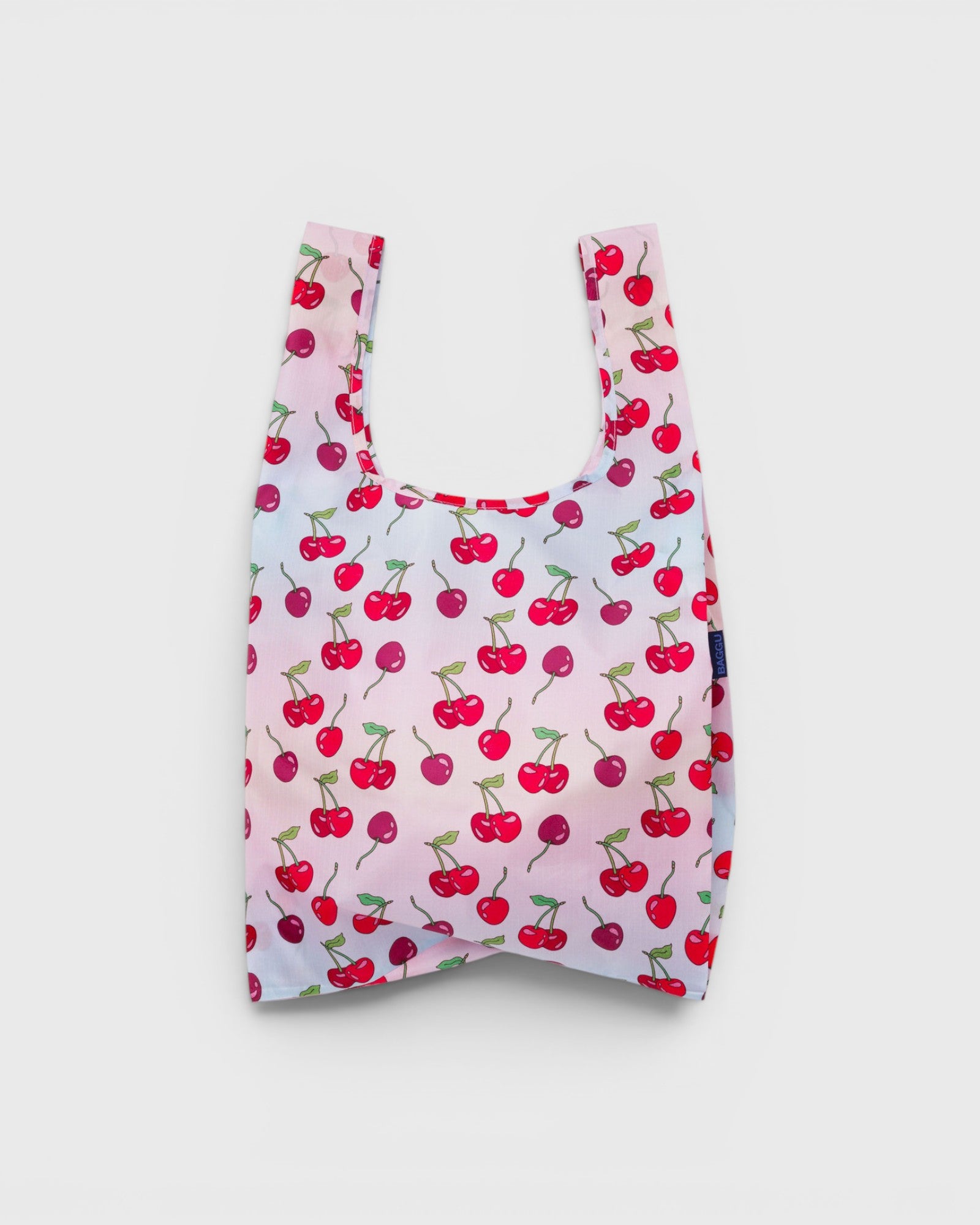 JONES + CO reusable grocery bag in pink nylon with a red cherry print pattern