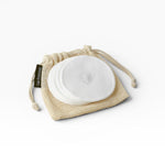 JONES + CO reusable white cotton rounds in a mesh bag for makeup removal and cleansing.