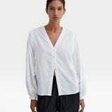 JONES + CO Rodas Blouse: White organic cotton voile with tone-on-tone check, V-neck, long gathered sleeves, mother-of-pearl buttons.
