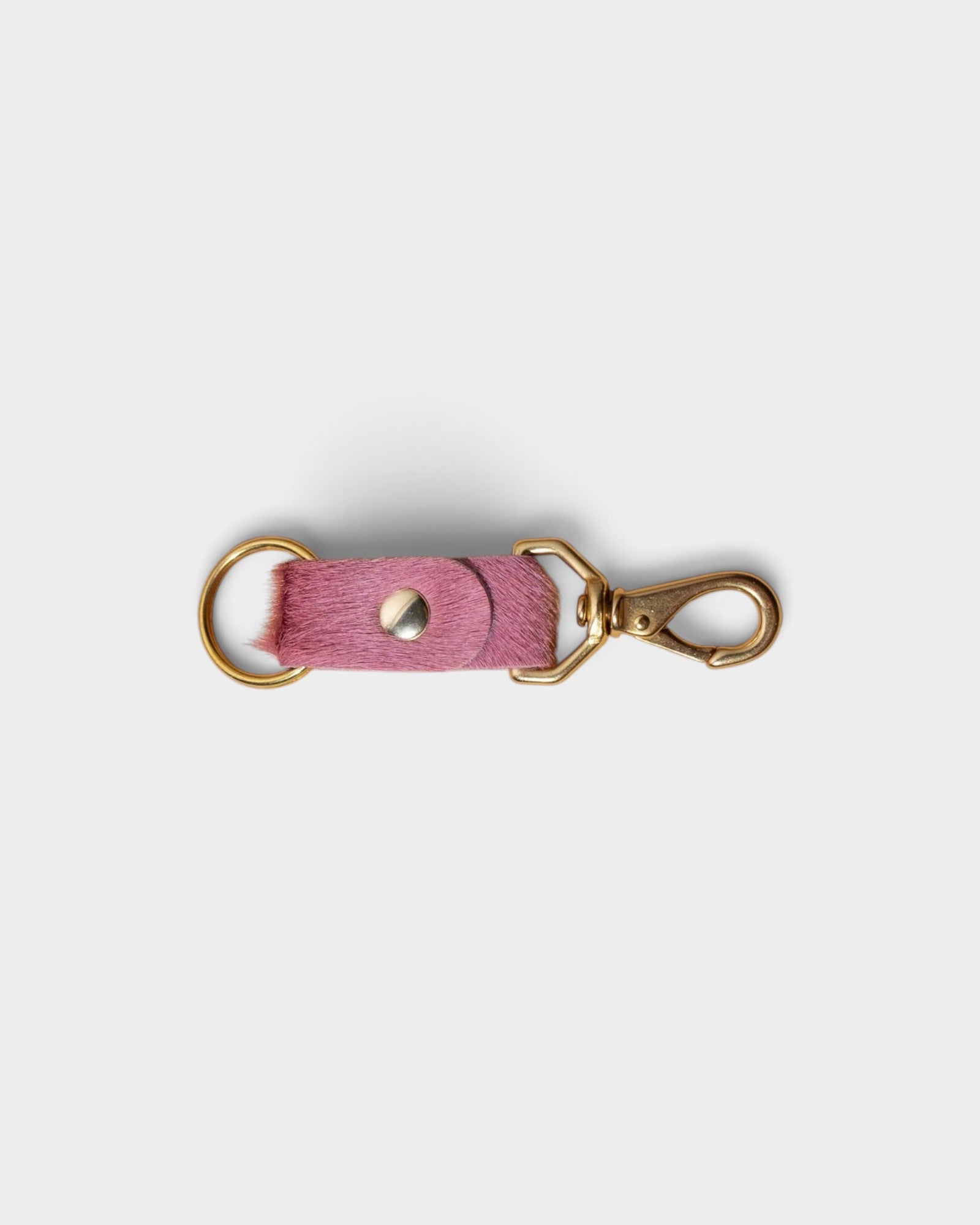 JONES + CO rose hair on hide keychain with solid brass keyring and clip on a light grey background