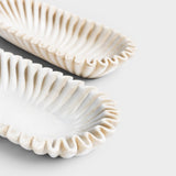 JONES + CO Ruffle Marble Oval Bowl with fluted edges and natural stone veining. Decorative accent.