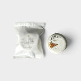 JONES + CO Sea + Sun shower steamer in white packaging next to a round, citrus-topped aromatherapy shower tablet.