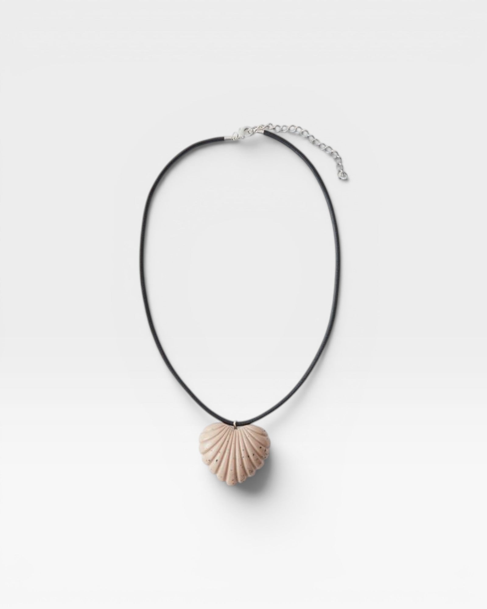 JONES + CO sculptural shell-inspired heart pendant necklace on black leather cord. Acrylic material.