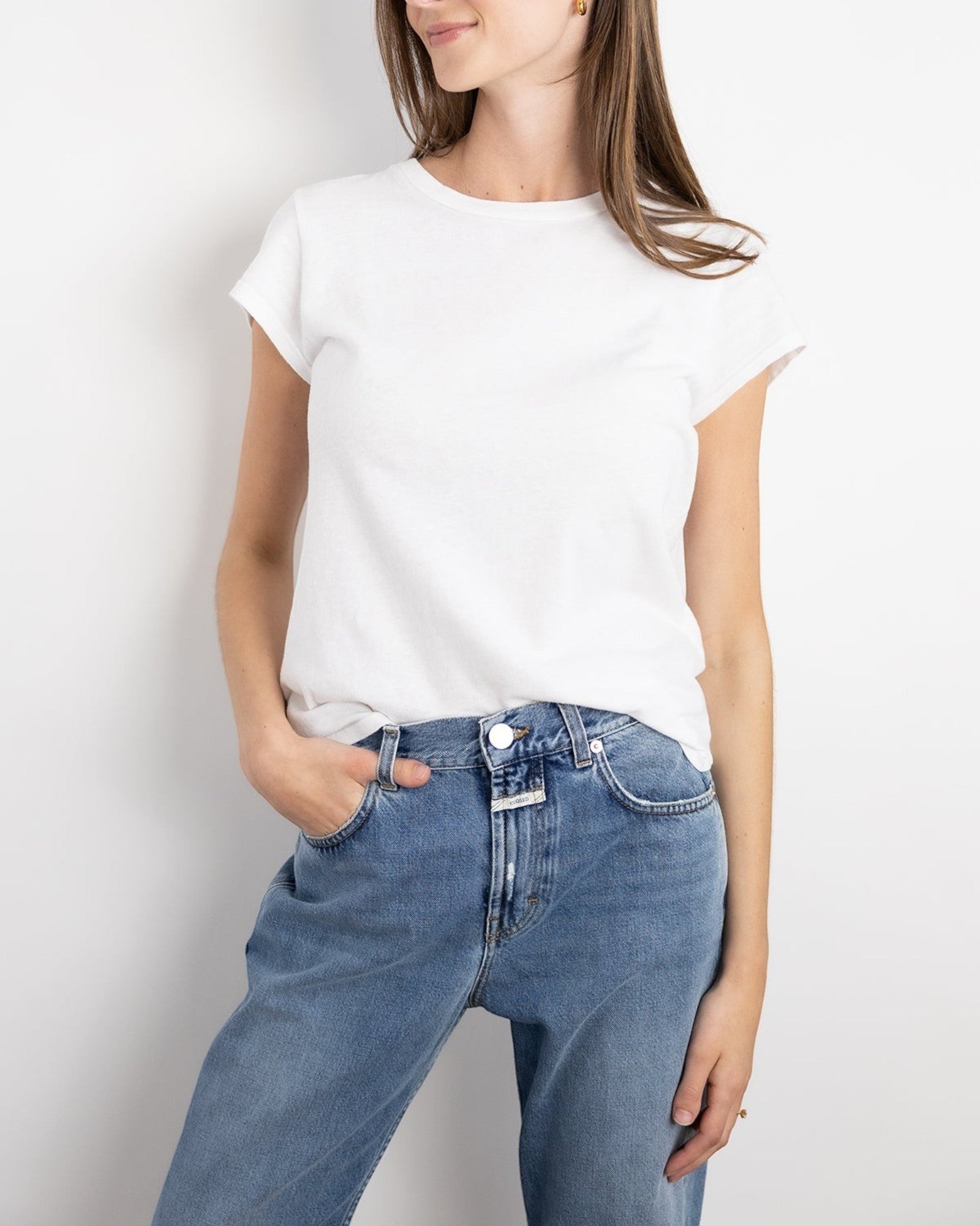 JONES + CO Sheryl baby tee in white organic cotton worn by a model with blue jeans