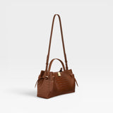JONES + CO Gyoza pouch in Sierra embossed leather with a crocodile texture, top handle, and adjustable shoulder strap.