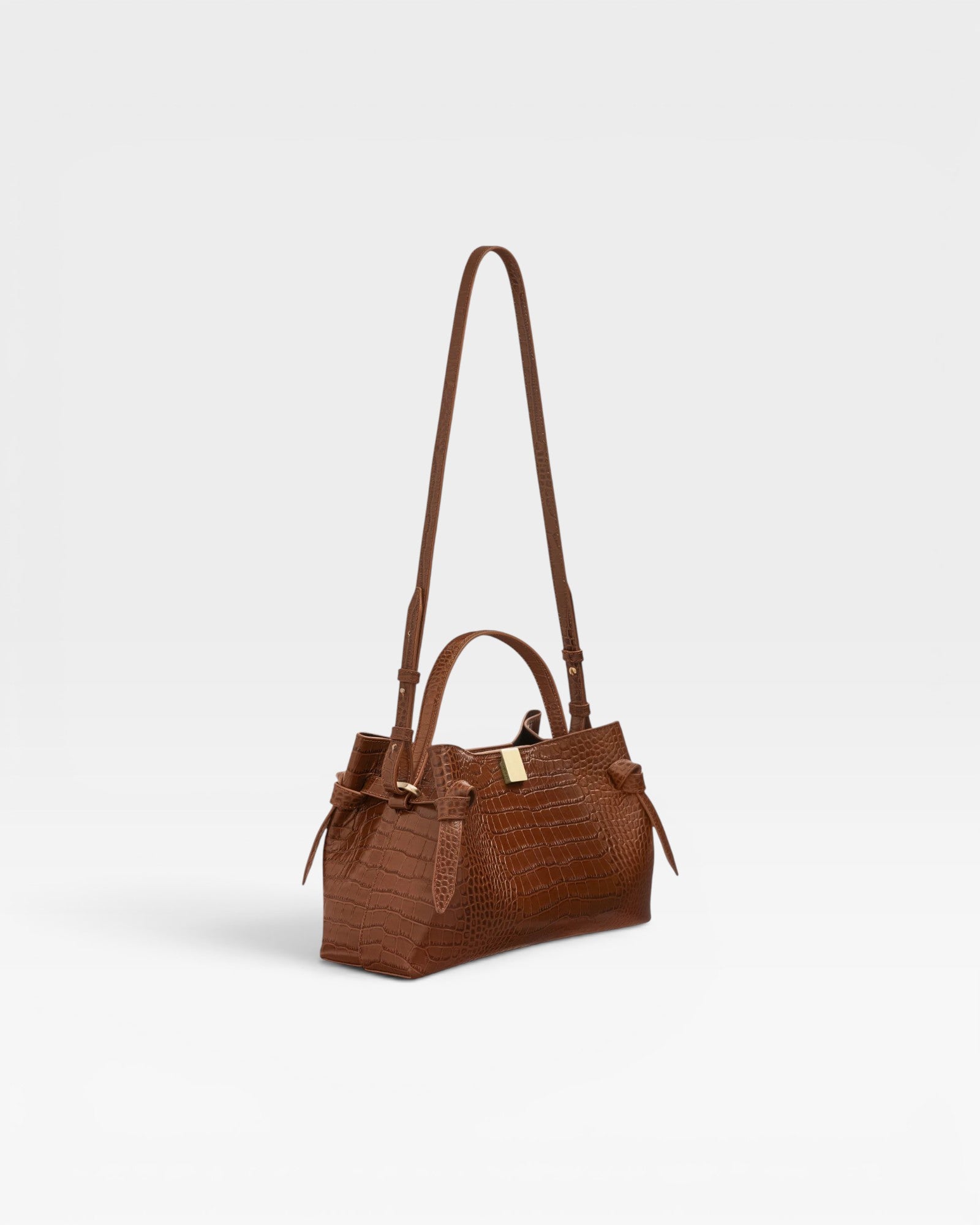 JONES + CO Gyoza pouch in Sierra embossed leather with a crocodile texture, top handle, and adjustable shoulder strap.