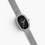 JONES + CO Jane Small watch with a silver woven mesh bracelet and a black oval dial on a white background.