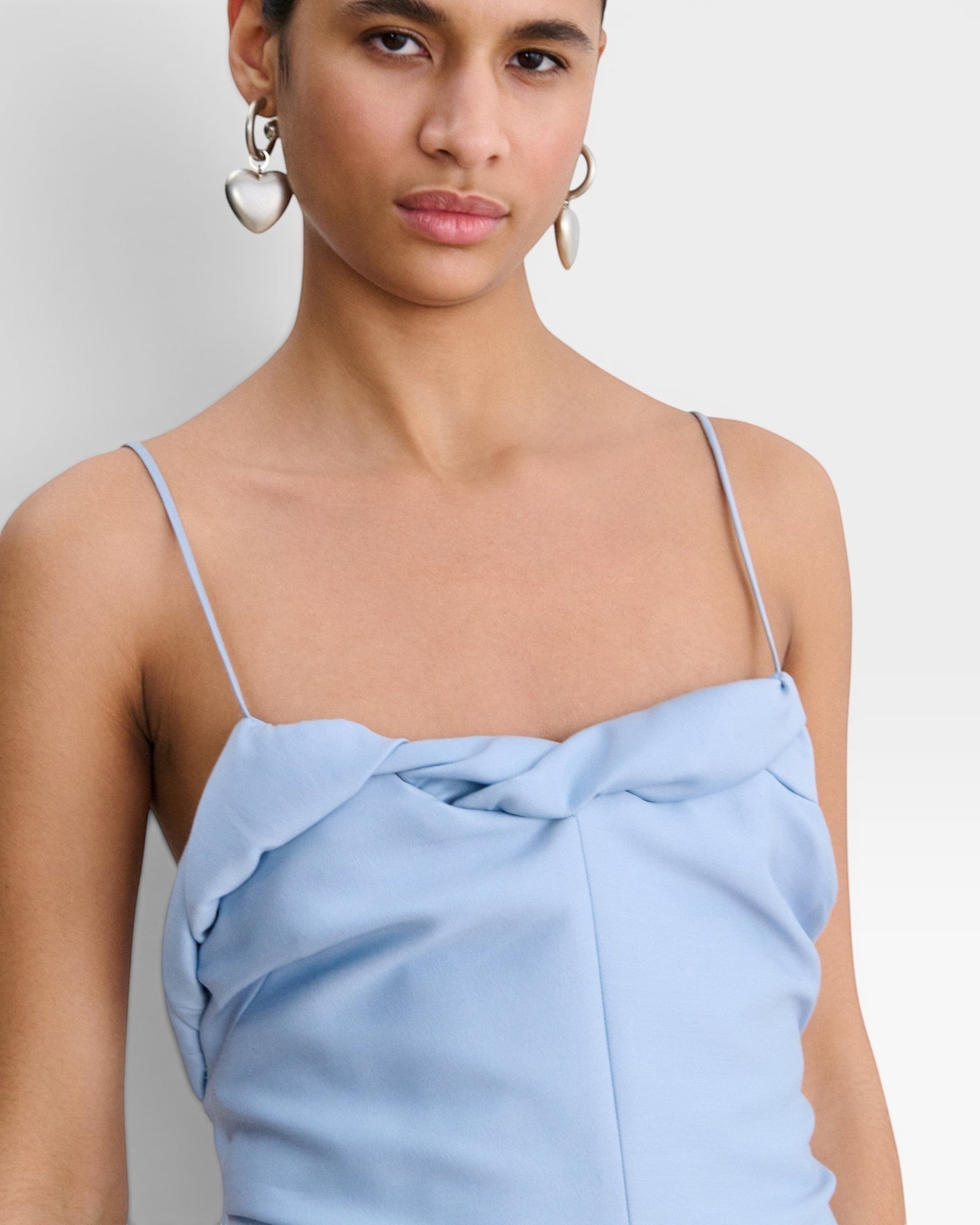 JONES + CO sky blue Priss dress featuring slim straps and a draped neckline detail on a model.