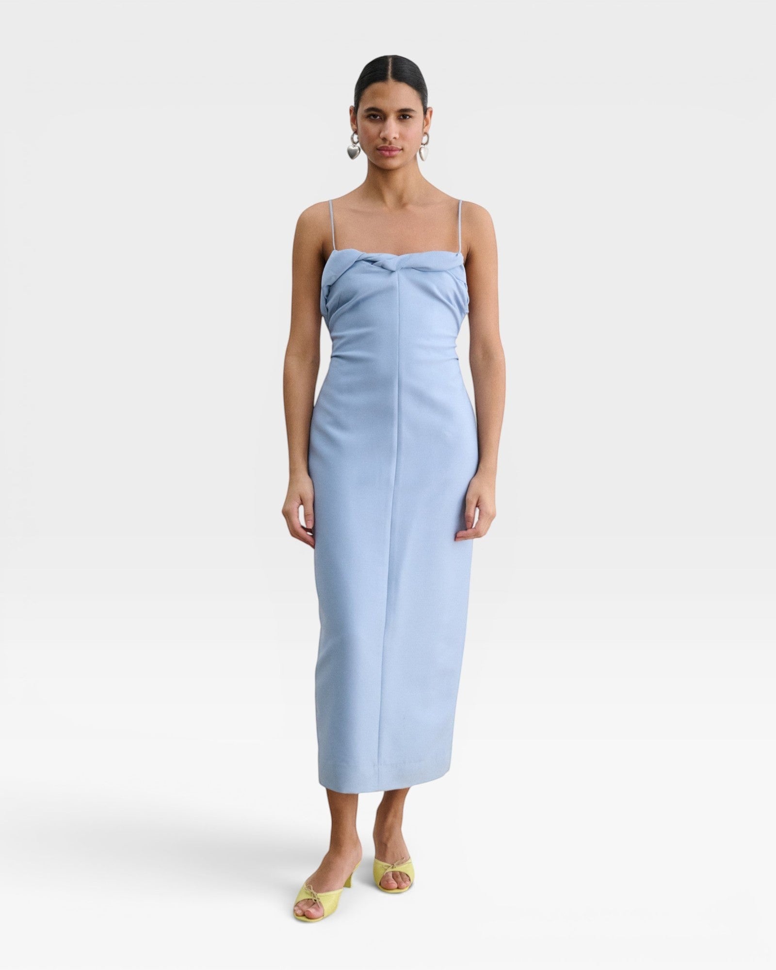 JONES + CO sky blue Manon wool midi dress with slim straps, draped neckline, and fitted waist on a model.