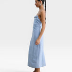 JONES + CO sky blue Manon wool midi dress with slim straps, draped neckline, and low-cut back on a model