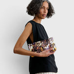 JONES + CO small envelope clutch with abstract floral watercolor print and hinge closure held by a woman
