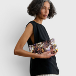 JONES + CO small envelope clutch with abstract floral watercolor print and hinge closure held by a woman