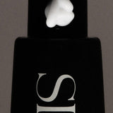 JONES + CO SOAKED Hand Serum with a dollop of white cream on the black pump dispenser.