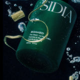 JONES + CO The SOAKED Wash, a champagne-hued hand and body cleanser with cypress and musk notes, submerged in water.