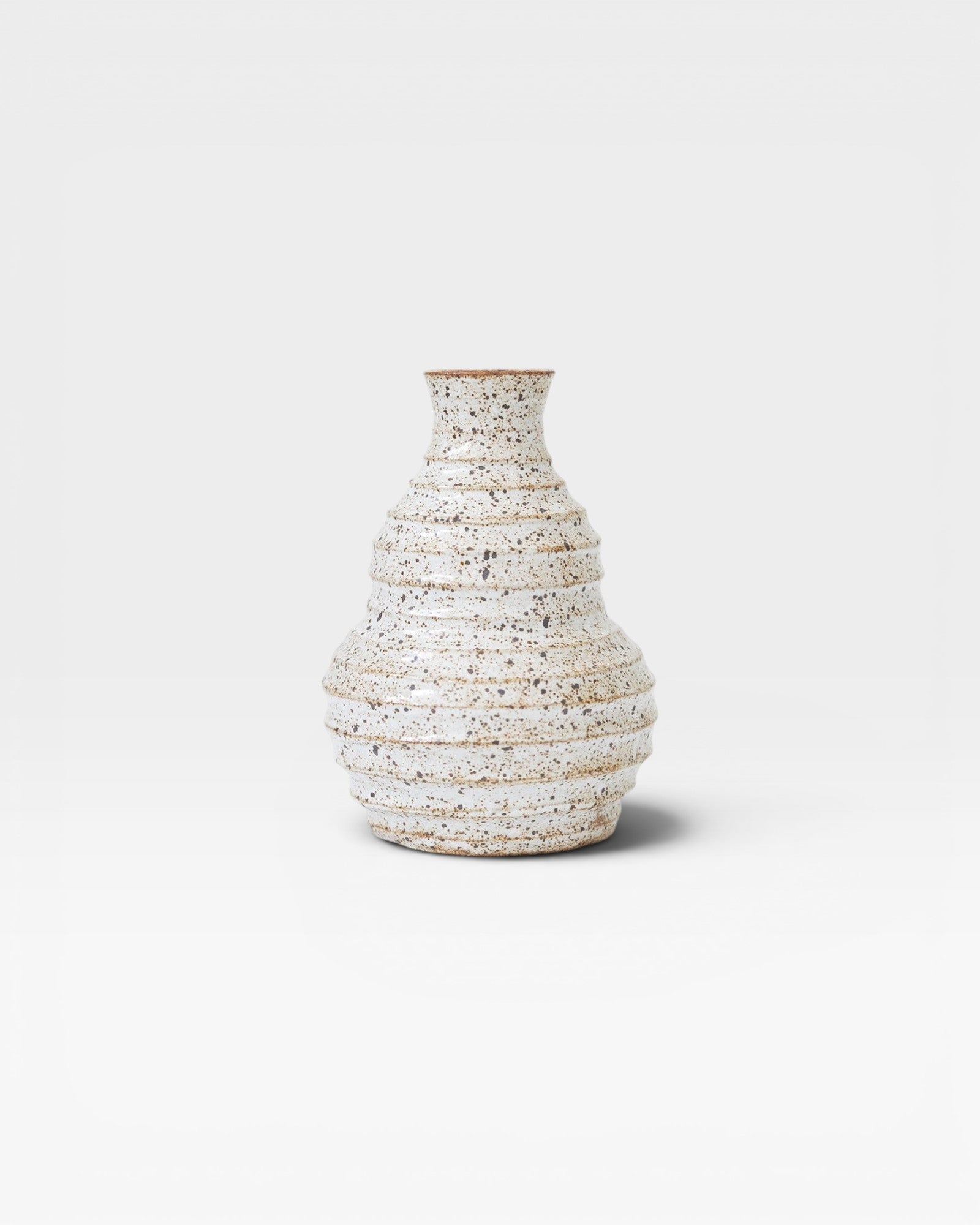 JONES + CO handmade speckled ceramic vessel with ribbed texture and sculptural form, off-white glaze.